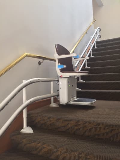 Stairlift with swivel seat feature for safe exit at top
