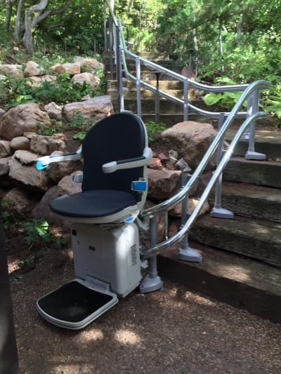 Stairlift installation in narrow stairwell with safety sensors